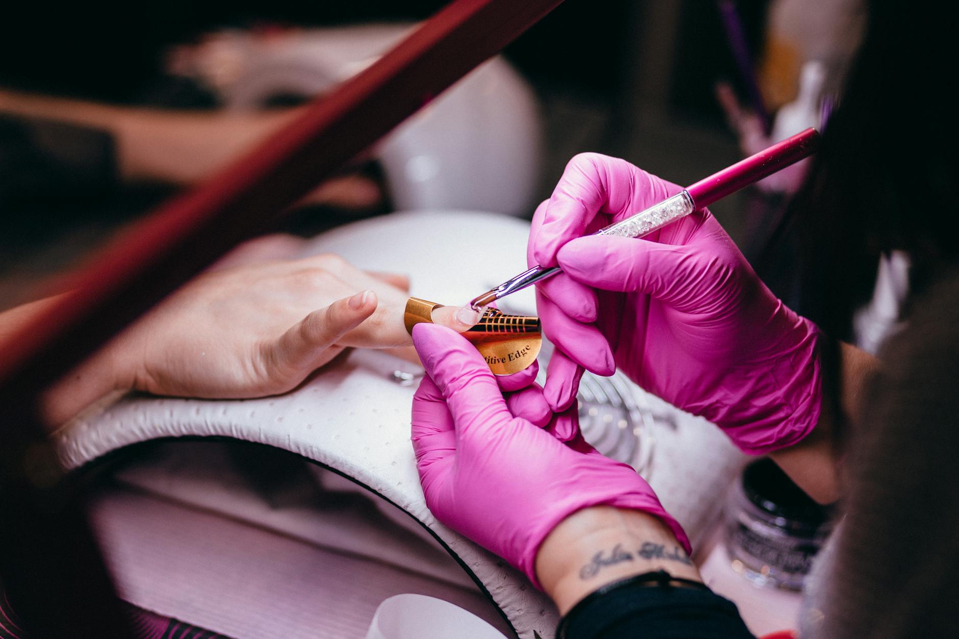 Stylistka wykonuje precyzyjny manicure z zdobieniem paznokci w salonie