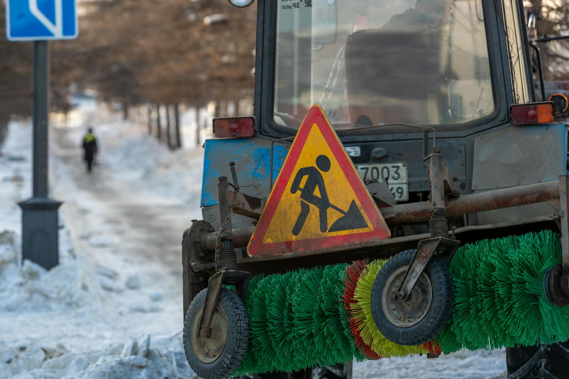 Pług śnieżny oczyszcza zaśnieżoną ulicę w zimowym mieście