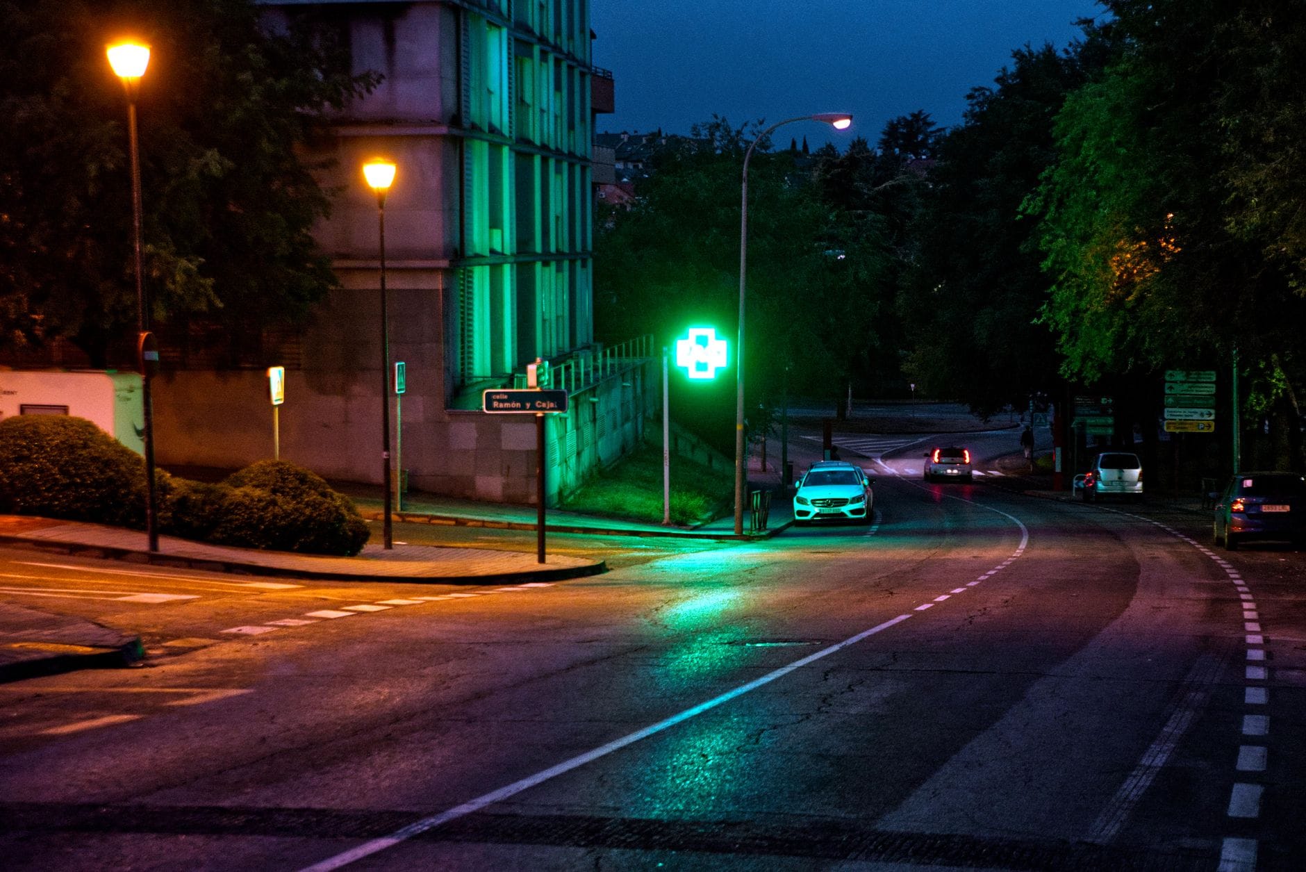Nocna ulica miejska oświetlona latarniami i światłami samochodów