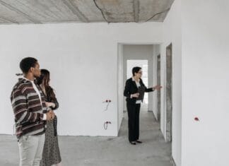 Para ogląda niewykończone mieszkanie z agentem nieruchomości